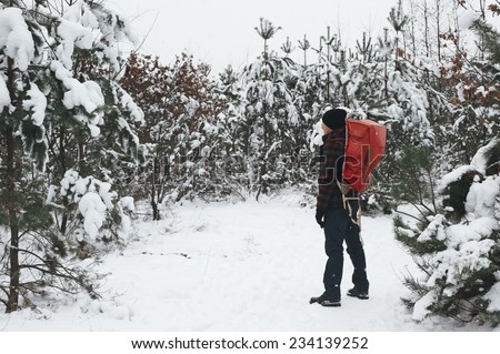 man in the winter forest on the walk with old backpack