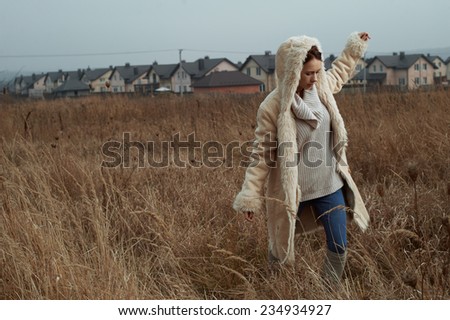 woman on the walk in fields behind country town