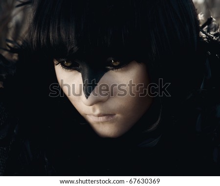 raven girl with short black hair. around the neck of her black feathers. Facial face art that makes her look like a crow. her back the sun is shining, but the street is still cold