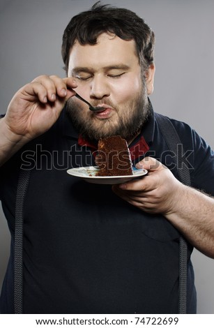 Fat Guy Eating. stock photo : funny fat guy eating chocolate cake in studio