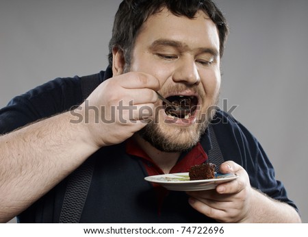picture of fat kid eating cake. fat guy eating cake. stock