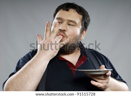 funny fat guy eating chocolate cake in studio