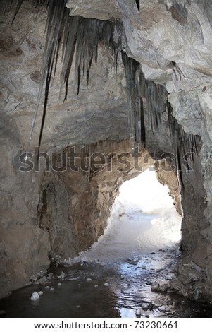 An old tunnel with a floor of ice excavated in the stone during the first global war, in the North of italian Alps