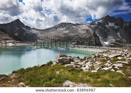 Dam and man-made lake between mountains. It’s Venerocolo Lake, North of Italy, Lombardy region, at 2.540 meters on the sea-level