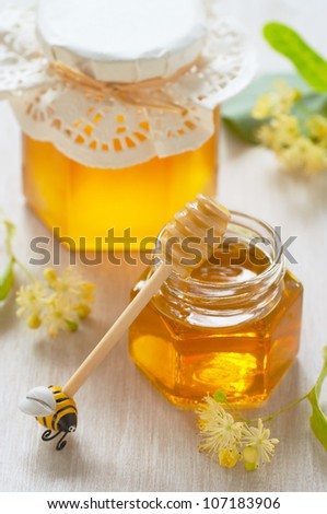 Two jars of linden honey and spoon of honey