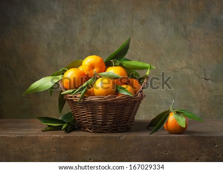 Still life with tangerines in a basket on the table