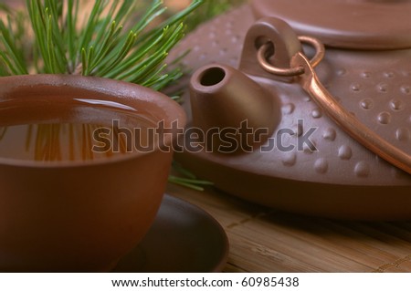 Ceramic teapot with a cup of tea