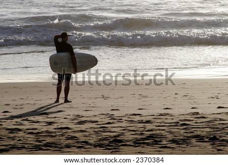 Early Morning Surf Check - Male Surfer Looking At The Ocean From The Beach