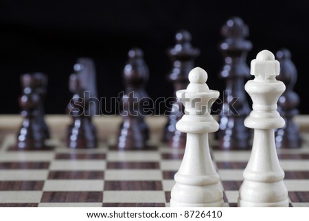 White Chess King And Queen In Focus, Black Pieces OOF