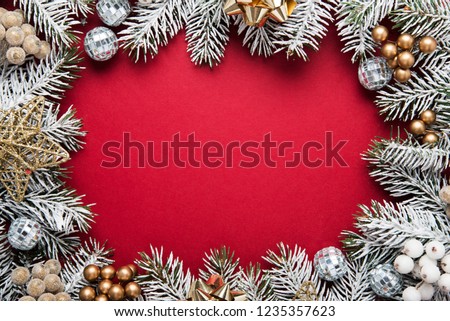 Merry Christmas and Happy Holidays greeting card, frame, banner. New Year. Noel. Silver, white and red Christmas ornaments and fir tree on red background top view. Winter holiday xmas theme.