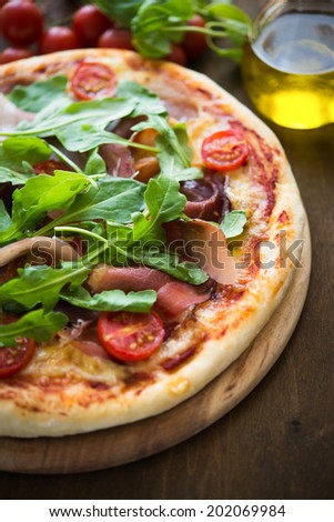 Pizza with prosciutto and arugula (salad rocket)
