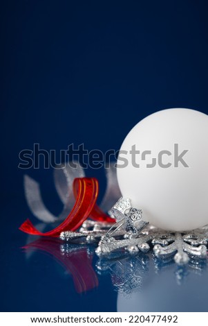 White, red and silver christmas ornaments on dark blue xmas background with space for text