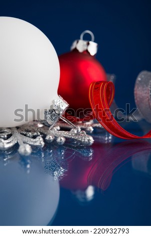 White, red and silver christmas ornaments on dark blue xmas background with space for text
