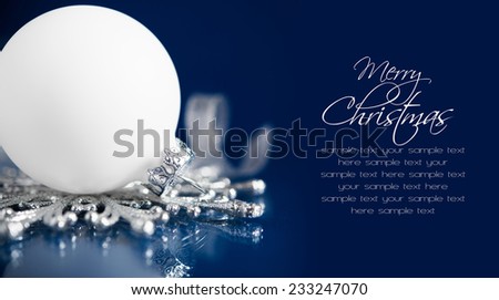 Silver and blue christmas ornaments on dark blue background with space for text. Sample text on solid color, easy to delete. Merry christmas card. Winter holidays. Xmas theme.