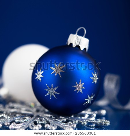 Silver, white and blue christmas ornaments on dark blue background with space for text. Merry christmas card. Winter holidays. Xmas theme.