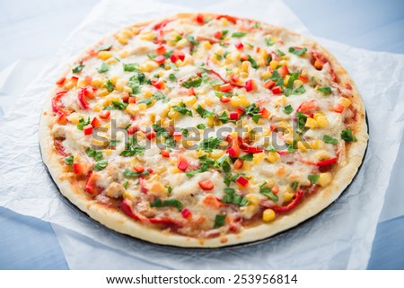 Pizza with mozzarella cheese, chicken, sweet corn, sweet pepper and parsley. Italian cuisine.