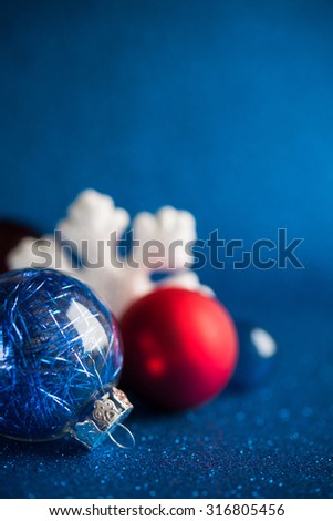 White, silver and red christmas ornaments on dark blue glitter background with space for text. Merry christmas card. Winter holidays. Xmas.