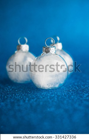 White christmas ornaments on dark blue glitter background with space for text. Merry christmas card. Winter holidays. Xmas theme.