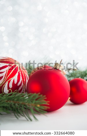 Red xmas ornaments and xmas tree on glitter holiday background. Merry christmas card. Winter holidays. Xmas theme. Space for text. Happy New Year.