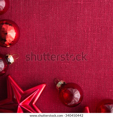 Red christmas decorations (stars and balls) on red canvas background. Merry christmas card. Winter holidays. Xmas theme. Happy New Year.
