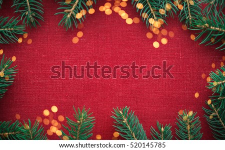 Christmas background with xmas tree and sparkle bokeh lights on red canvas background. Merry christmas card. Winter holiday theme. Happy New Year. Space for text.