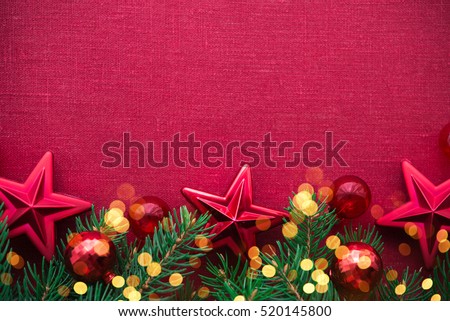 Christmas background with xmas tree, red ornaments and glowing golden bokeh lights on red canvas background. Merry christmas card. Winter holiday theme. Space for text. Happy New Year.