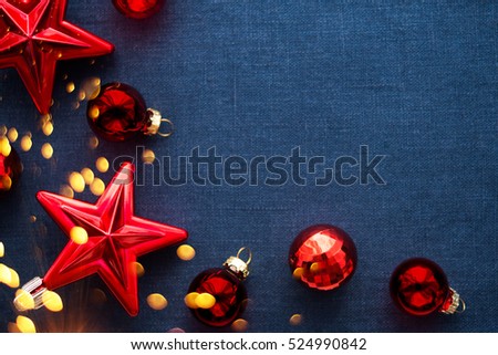 Christmas background with red ornaments and sparkle bokeh lights on blue canvas background. Merry christmas card. Winter holiday theme. Happy New Year. Space for text.