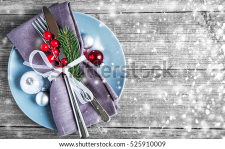 Christmas dinner plate decoration with xmas ornaments on old wood background. Merry christmas card. Winter holiday theme. Happy New Year. Space for text. Glitter snow effect
