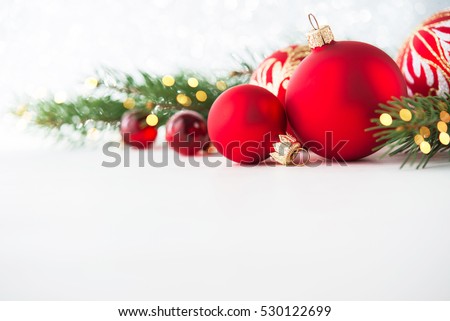 Red christmas ornaments on white background with xmas tree, twinkle bokeh lights. Merry christmas card. Winter holiday xmas theme. Happy New Year. Space for text.