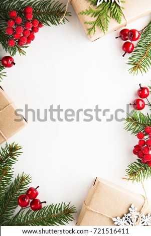 Christmas background with xmas tree, gift boxes and red berries on white wooden background. Merry christmas greeting card, frame, banner. Winter holiday theme. Happy New Year. Flat lay.