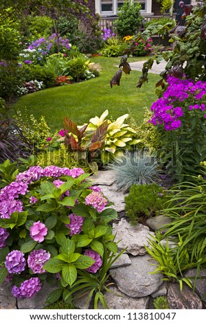 Lush Landscaped Garden With Flowerbed And Colorful Plants