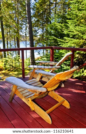 Wooden deck at forest cottage with Adirondack chairs