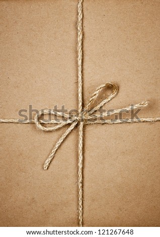 Gift package wrapped in brown paper tied with twine closeup