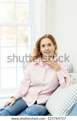 Smiling caucasian woman relaxing on couch by window