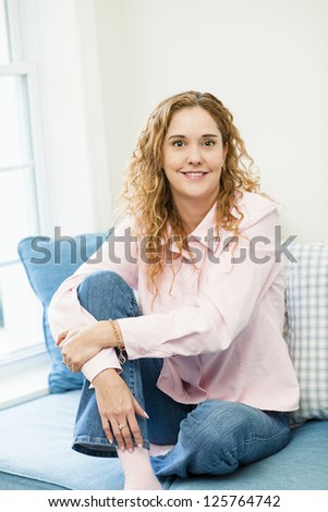 Smiling caucasian woman relaxing on couch by window