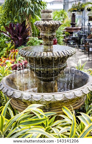 Cascading concrete fountain in garden nursery store with water flowing