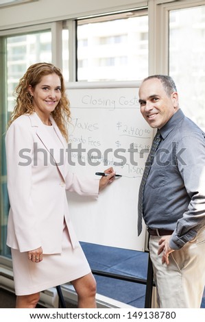Real estate agent using flip chart with closing cost data