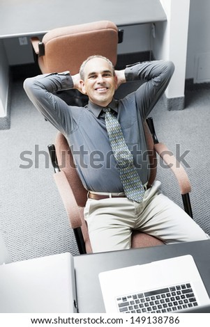 Businessman with laptop computer sitting at office workstation