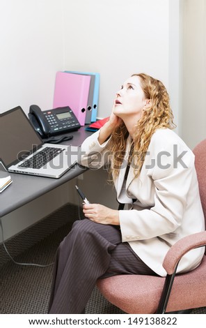 Businesswoman worried in office workstation looking up