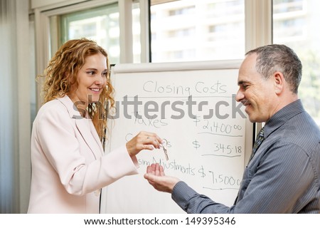 Female real estate agent giving keys to new home buyer