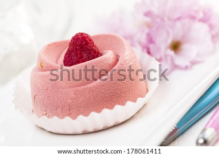 Closeup of pink raspberry mousse dessert with cherry blossom