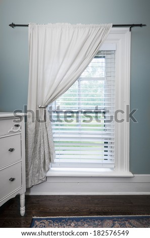 Window with venetian blinds and white curtain in country style room