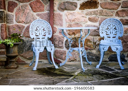 Blue painted metal outdoor furniture on stone patio