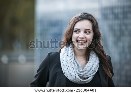 Candid portrait of young brunette woman smiling and looking to side with copy space