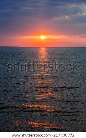Setting sun with dramatic red sky over Atlantic Ocean in Prince Edward Island, Canada