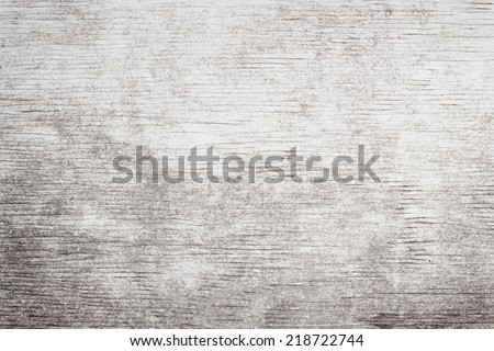 Gray wooden background of weathered distressed rustic wood with faded white paint showing woodgrain texture