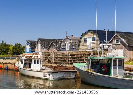 CAVENDISH, PRINCE EDWARD ISLAND, CANADA - JULY 15 2013: Fishing boats docked near lobster traps shown on July 15, 2013 in Cavendish, Prince Edward Island, Canada