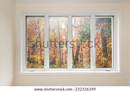 Large four pane window looking on colorful fall forest