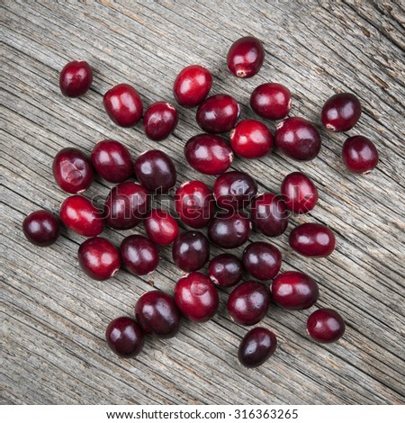 Heap of fresh red ripe cranberries on rustic wood background, square format