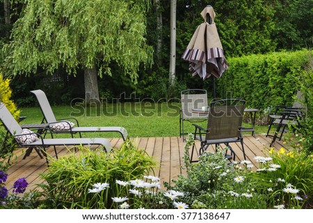 Wooden patio or deck in backyard of a home with outdoor furniture